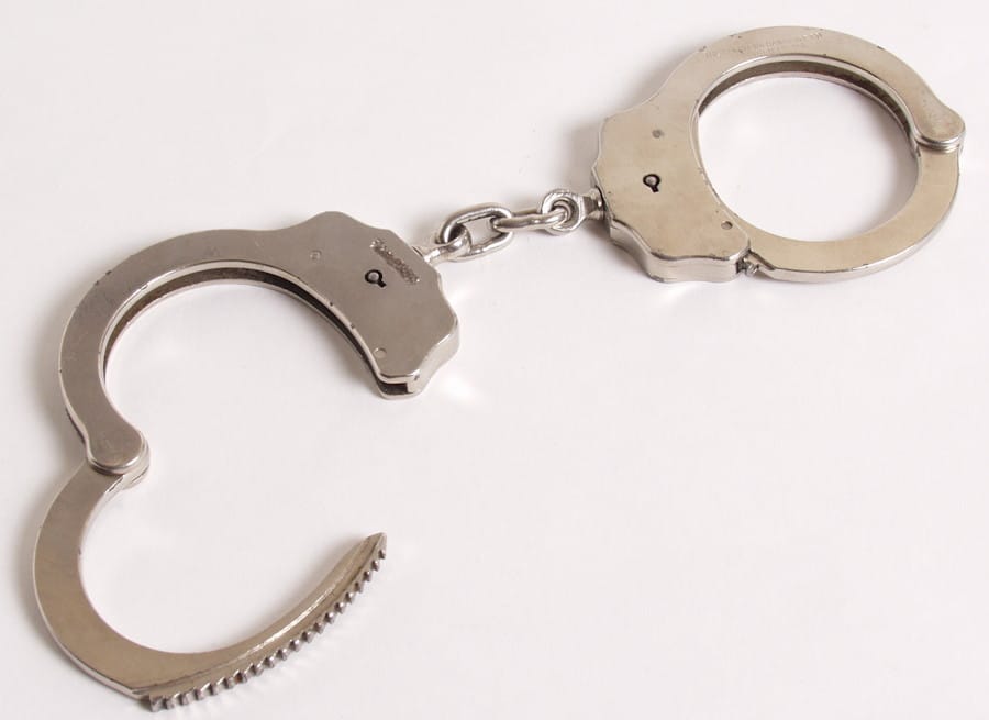 Photo of a pair of metal handcuffs - one open and one closed. (Original: https://morguefile.com/p/3245; By: https://morguefile.com/creative/mconnors)